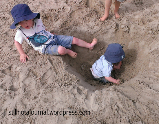 Experimenting with different styles of parenting. I believe this one's 'Turtle Style' which I mentioned in my last post, ie dig a hole in the beach and leave your kid in it. They seem to like it and at least they stay where you left them.